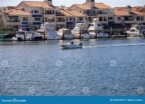A Man Sailing A Small Motor Boat At Huntington Harbour With Boats And A Man Sailing A Small Motor Boat At Huntington Harbour With Boats And